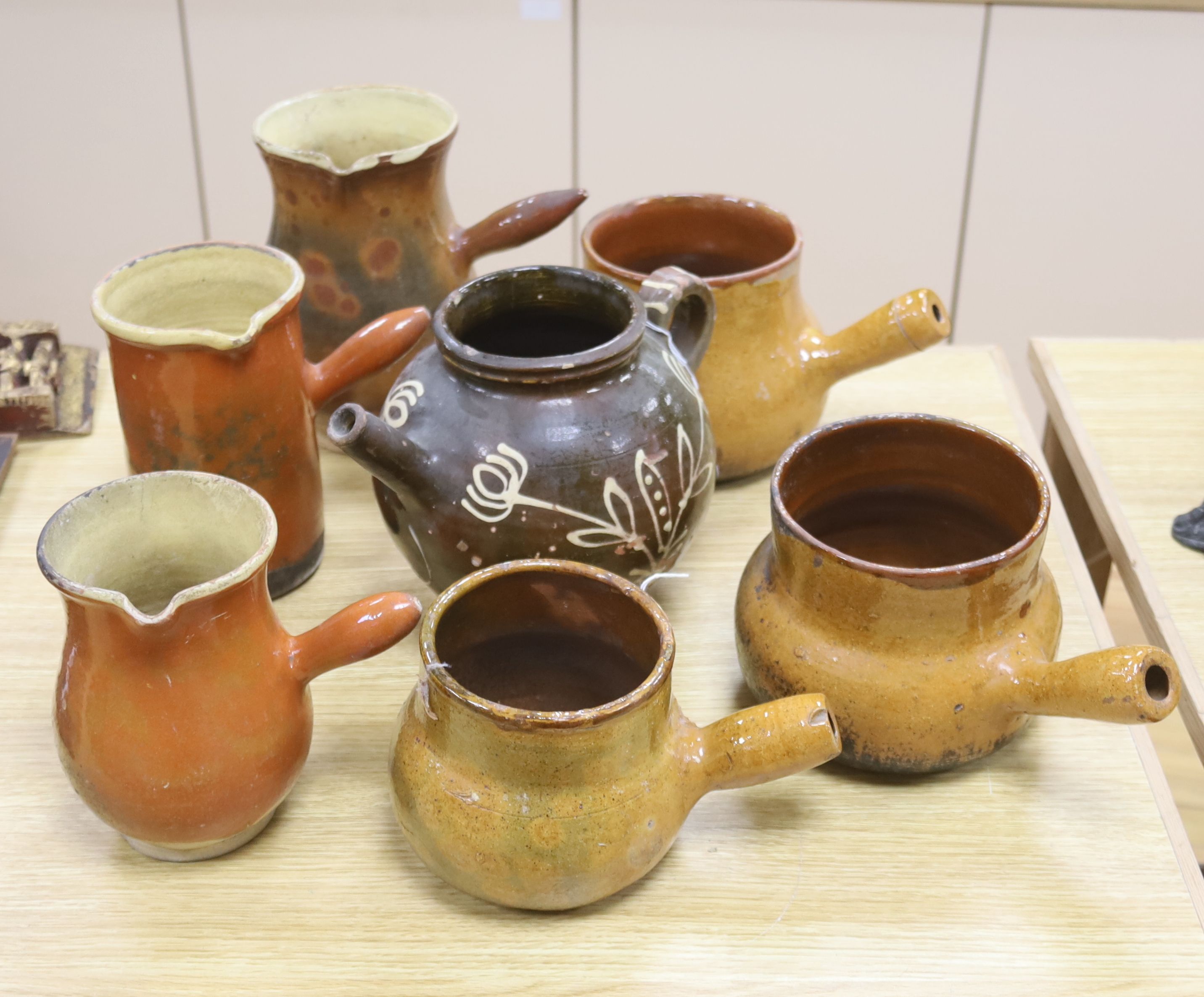 Six vintage Continental, probably French, glazed stoneware cooking pots and a slip-decorated stoneware confit pot